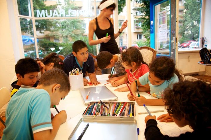 Children drawing at a long table in a gallery, Berlin