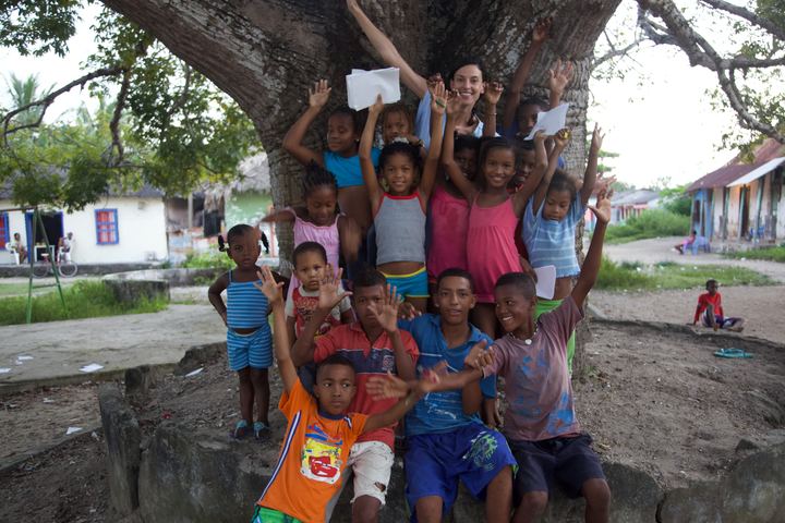 A group of children cheering under a big tree, Barú